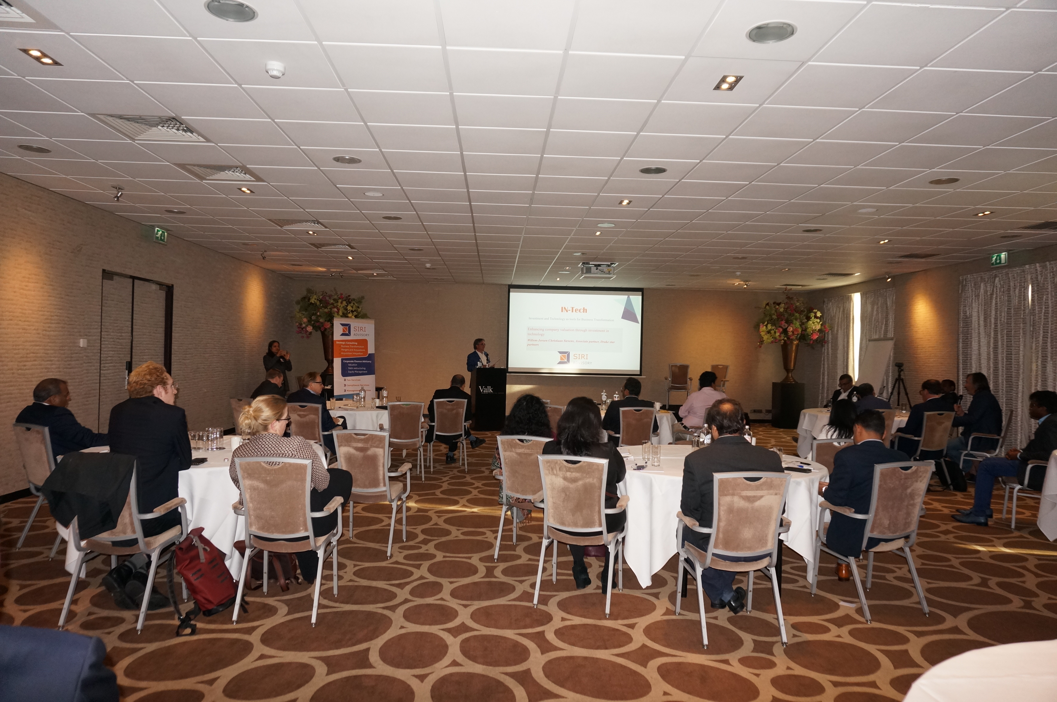Speaker presenting at the IN-Tech event to an audience of business leaders